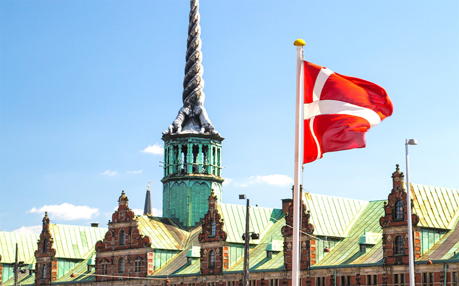 Die dänische Flagge vor einem Kirchturm in Kopenhagen