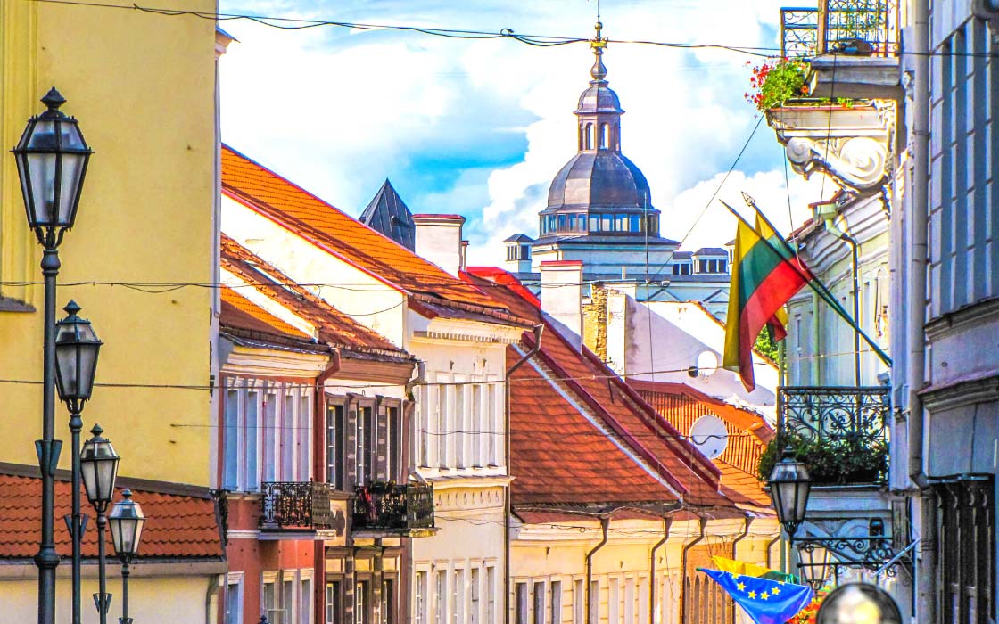 Altstadt von Vilnius mit zwei litauischen Flaggen, die rechts aus einer Hauswand ragen