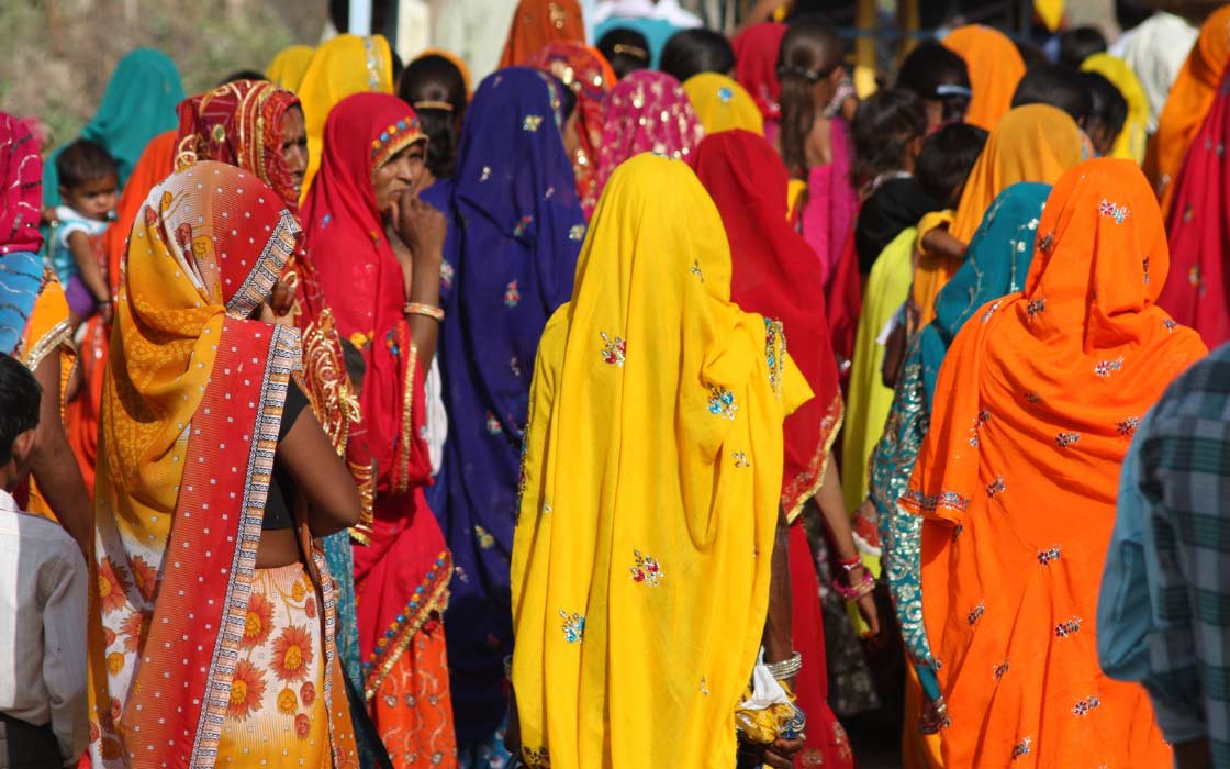 Mehrere Personen die verschiedenfarbige Saris tragen