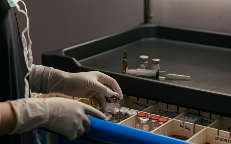 Person holt Medikamente aus einem Medizinschrank