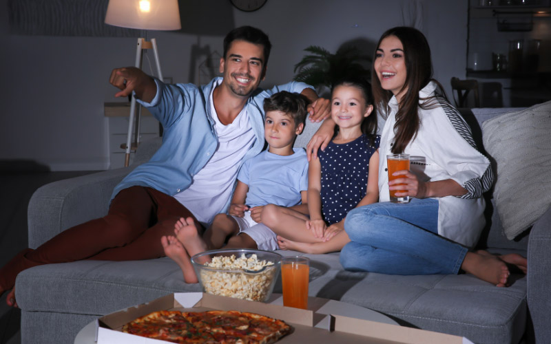 Familie sitzt vor dem Fernseher